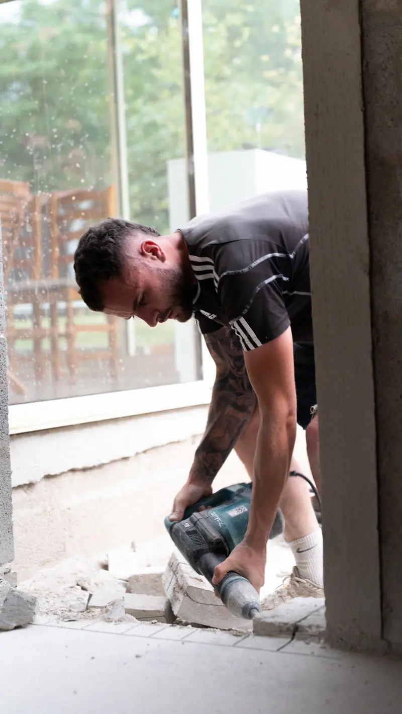 Killian Perrin au perforateur sur un chantier de rénovation