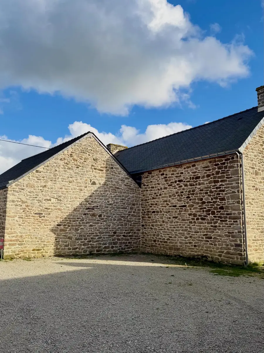 Deux volumes en pierre aux joints refaits donnant sur une cour en gravier