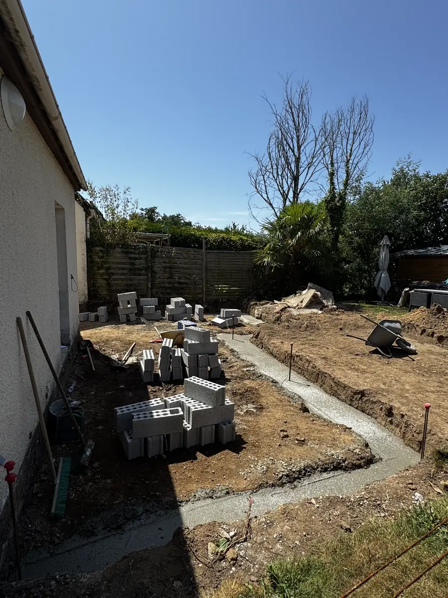Fondations terminées et palettes de parpaings livrées sur le chantier